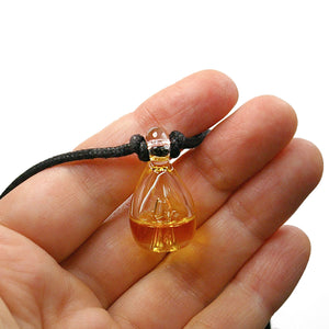 Clear Pixie Glassworks Aromatherapy Pendant filled with a yellowish essential oil 